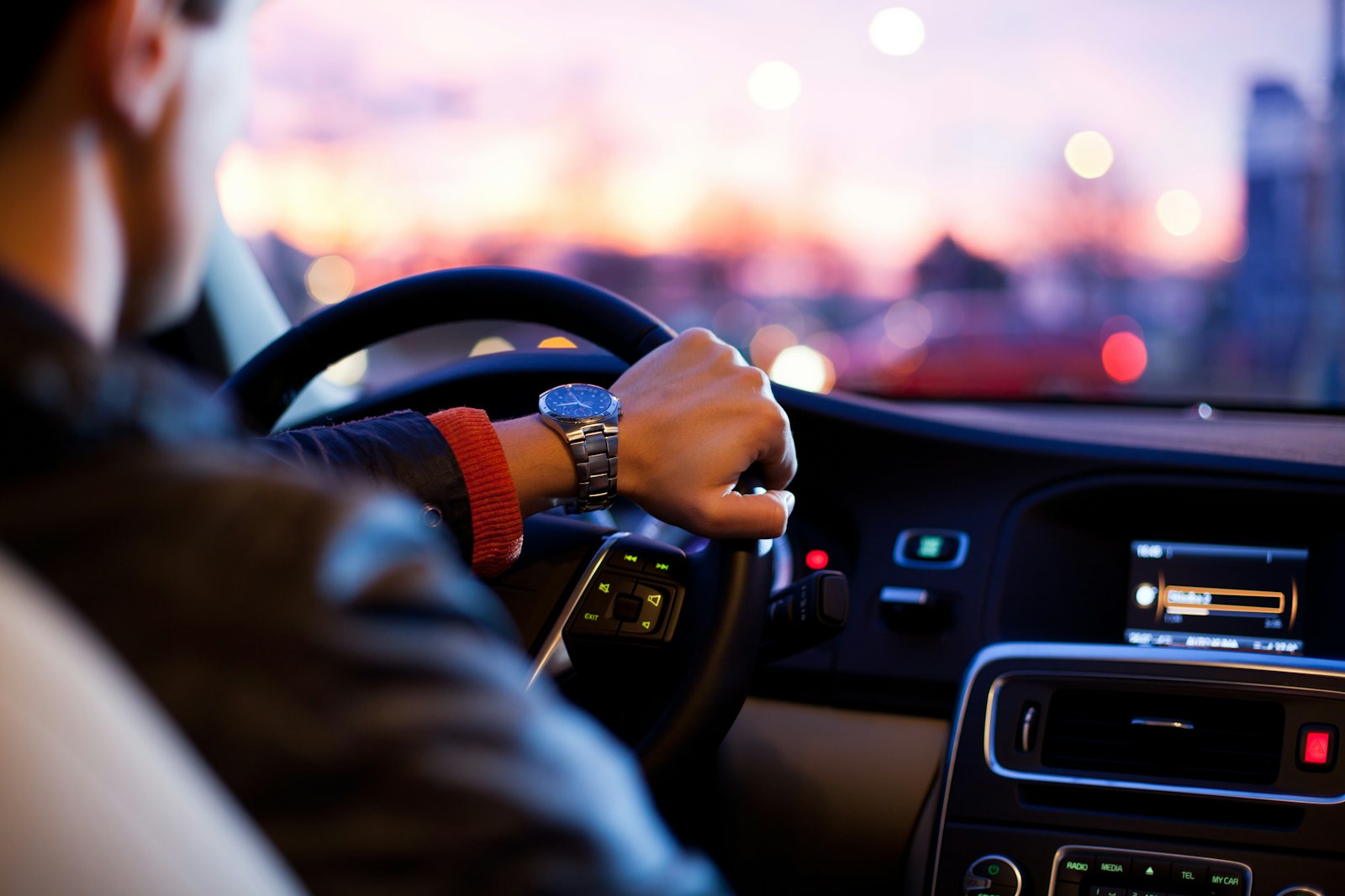Ride-hailing driver checking phone while driving in the city